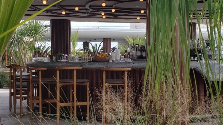 outdoor bar with wooden stools and plants