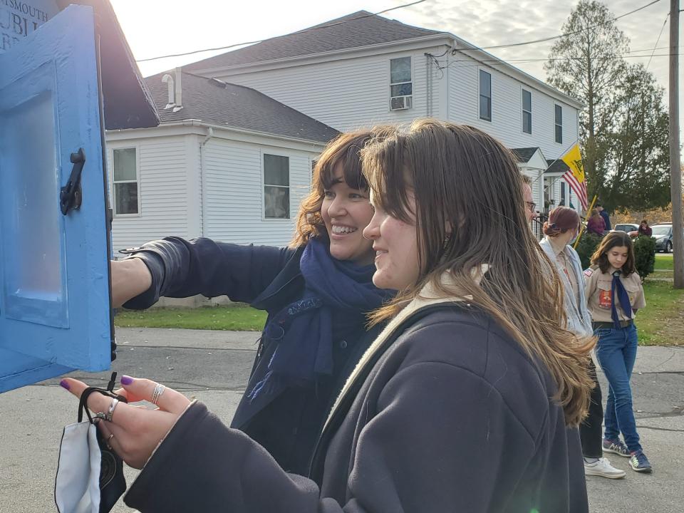 Loreley Godfrey and Portsmouth Librarian Laura Horwood-Benton examine the books added to fill  Gosling Meadows neighborhood's first Little Free Library Sunday, Nov. 21, 2021.