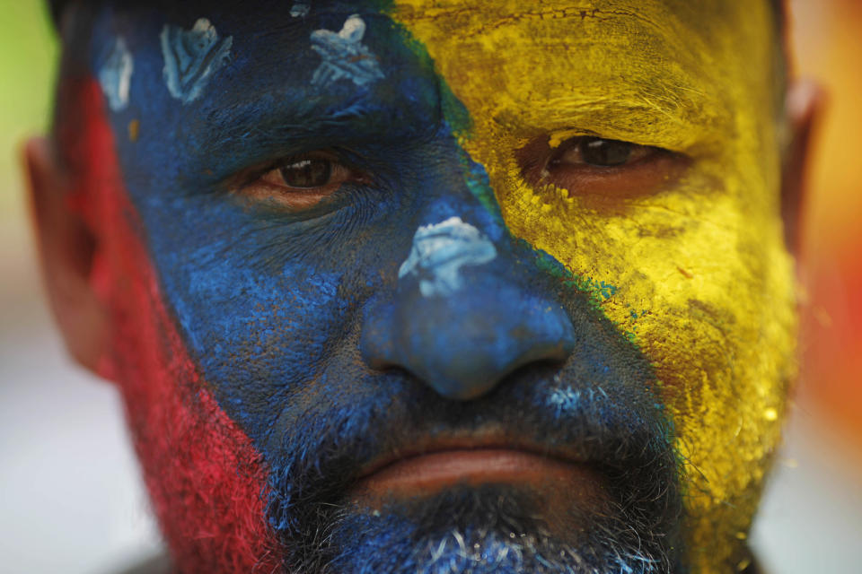 �¹A supporter of Venezuela's acting President Nicolas Maduro stands with his face painted in the colors of his nation's flag outside the national electoral council where Maduro registers his candidacy for president to replace late President Hugo Chavez in Caracas, Venezuela, Monday, March 11, 2013. Presidential elections were announced to take place on April 14, after Maduro announced on March 5 that Chavez had died. (AP Photo/Rodrigo Abd)