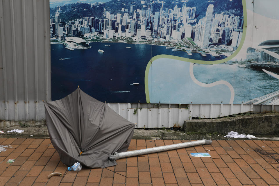 In this Friday, June 14, 2019, photo, a broken umbrella left in the aftermath of Wednesday's violent protest against proposed amendments to an extradition law is seen in Hong Kong. Umbrellas became a symbol of protest in Hong Kong in 2014 after demonstrators used them to shield themselves from both police pepper spray and a hot sun. Five years later, umbrellas were out in force again on Wednesday as thousands of protesters faced off with police outside the legislature. (AP Photo/Vincent Yu)