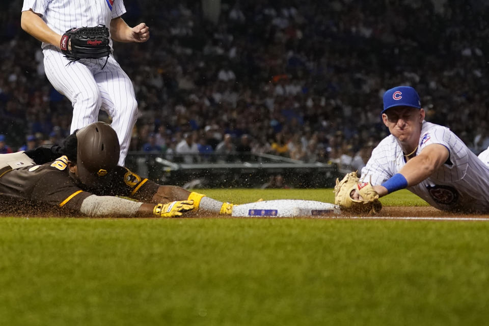 Chicago Cubs first baseman Frank Schwindel, right, dives and forces San Diego Padres' Jurickson Profar out at first as starting pitcher Justin Steele also covers during the first inning of a baseball game Monday, June 13, 2022, in Chicago. (AP Photo/Charles Rex Arbogast)