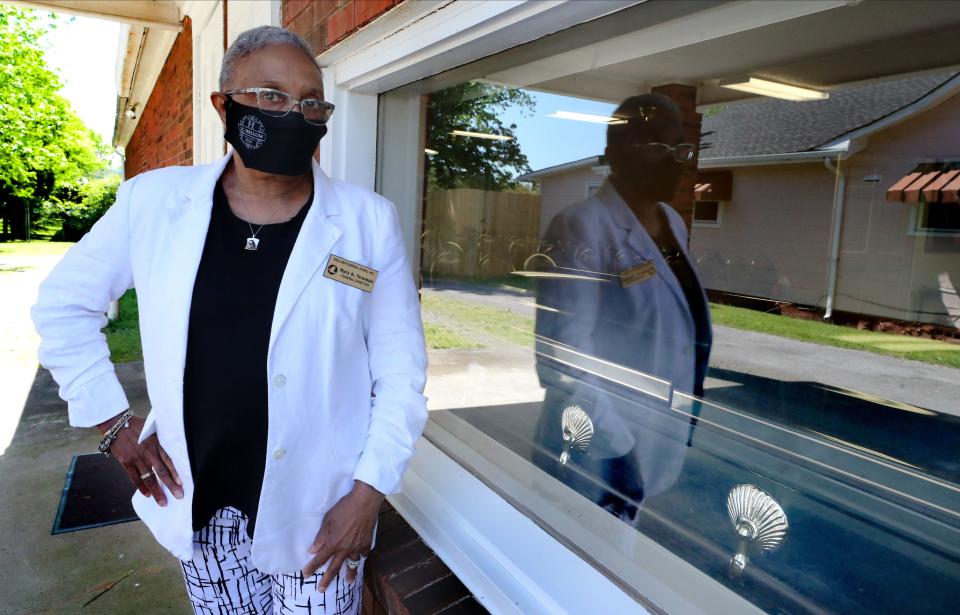 Mary "Kat" Newman, a funeral director at Hellum funeral home, in Murfreesboro, stands next to the window where family members and friends can drive by to view loved ones on Friday, May 1, 2020.