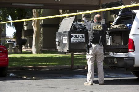 Police work inside a cordoned off area at the Autumn Ridge apartment complex which had been searched by investigators in Phoenix, Arizona May 4, 2015. REUTERS/Nancy Wiechec