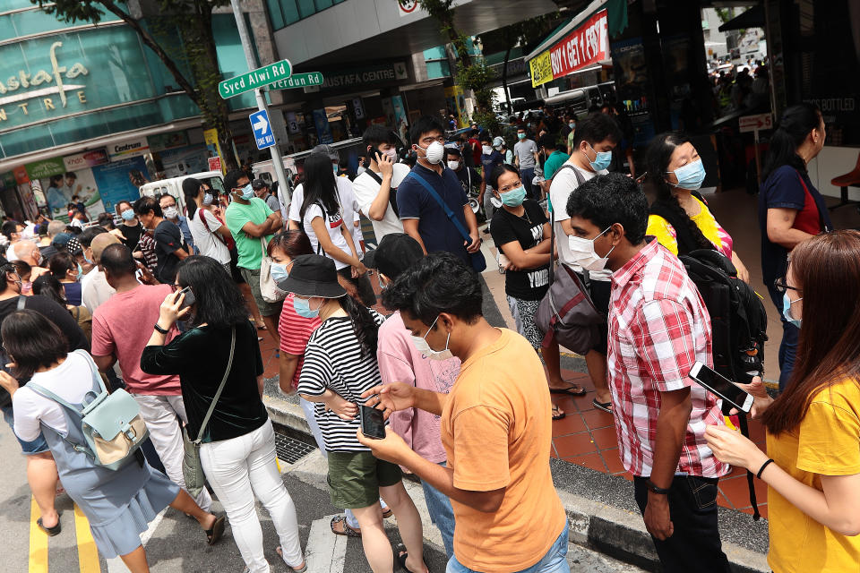 SINGAPORE - FEBRUARY 08:  People queue to buy protective masks at Mustafa Centre on February 8, 2020 in Singapore. Yesterday, Singapore raised its coronavirus outbreak alert to orange prompting many residents to put on masks with the World Health Organisation chief warned of a global shortage of masks and other protective equipment to fight against the novel coronavirus.  (Photo by Suhaimi Abdullah/Getty Images)