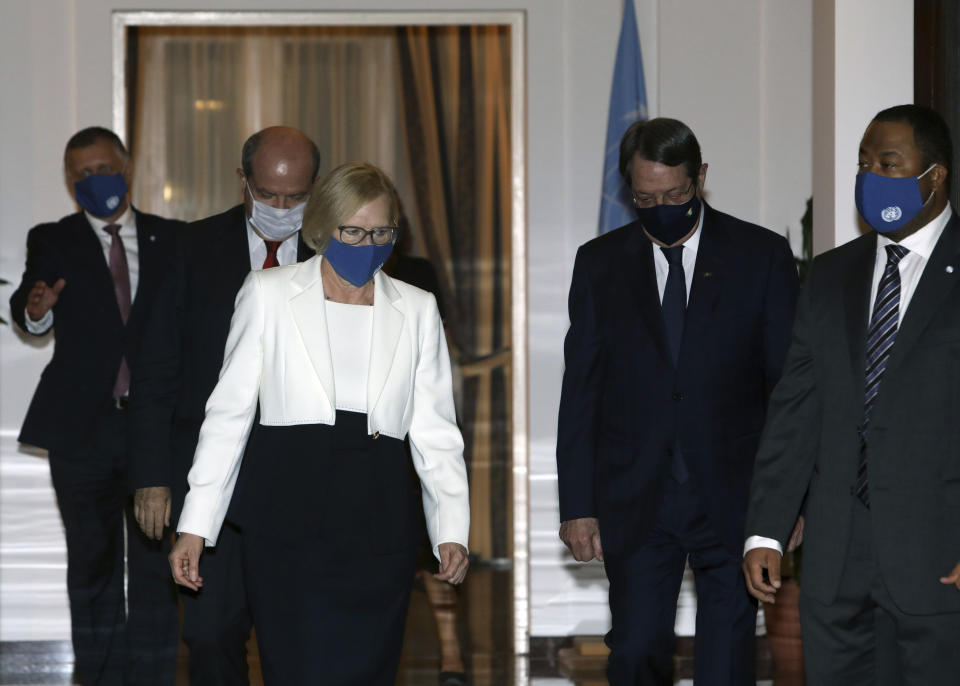 Turkish Cypriot leader Ersin Tatar, left center, Elizabeth Spehar, front left, head of the United Nations Peace Keeping Force in Cyprus and Nicos Anastasiades, second right, the Greek Cypriot President of war-divided Cyprus, stand in front of Spehar's official residence walk before their talks inside the U.N.-controlled buffer zone separating the breakaway Turkish Cypriot north from the internationally recognized Greek Cypriot south in the capital Nicosia, Cyprus, on Tuesday, Nov. 3, 2020. Anastasiades and Tatar held their first informal face-to-face meeting hosted by Spehar following Tatar's election as Turkish Cypriot leader last month amid hopes of a possible resumption of dormant reunification talks. (Katia Christodoulou Pool via AP)