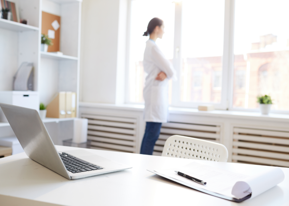 A doctor looks out the window of her office.