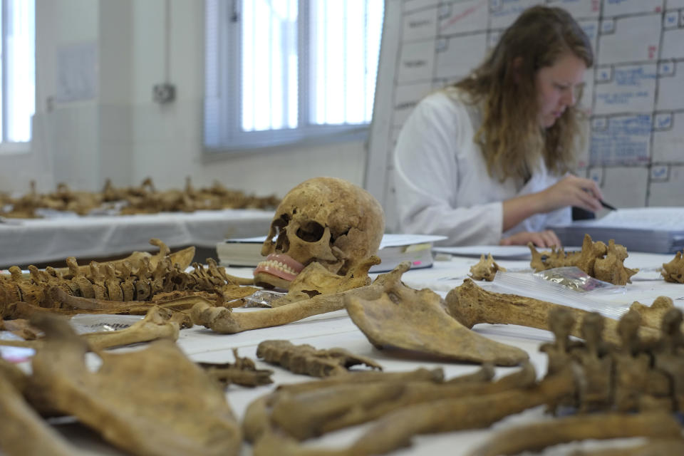 FILE - An anthropologist works on the remains of a missing person at the anthropologist laboratory of Cyprus Missing Persons (CMP) inside the U.N buffer zone in the divided capital Nicosia, Cyprus, May 31, 2017. U.S. academics who help locate Holocaust mass graves and execution sites in Eastern Europe have used high-tech, ground-penetrating radar to identify potential burial sites of people who disappeared amid war in Cyprus nearly a half century ago. (AP Photo/Petros Karadjias, File)