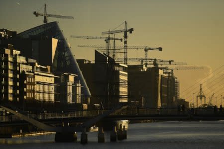 Construction cranes are seen at sunrise in the financial district of Dublin, Ireland October 18, 2018. REUTERS/Clodagh Kilcoyne