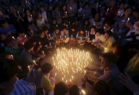 Local residents pray at a candlelight vigil to pay their respects to the victims of the sunken Eastern Star cruise ship on the Yangtze River, at a public square in Jianli, Hubei province, China, June 4, 2015. REUTERS/Stringer