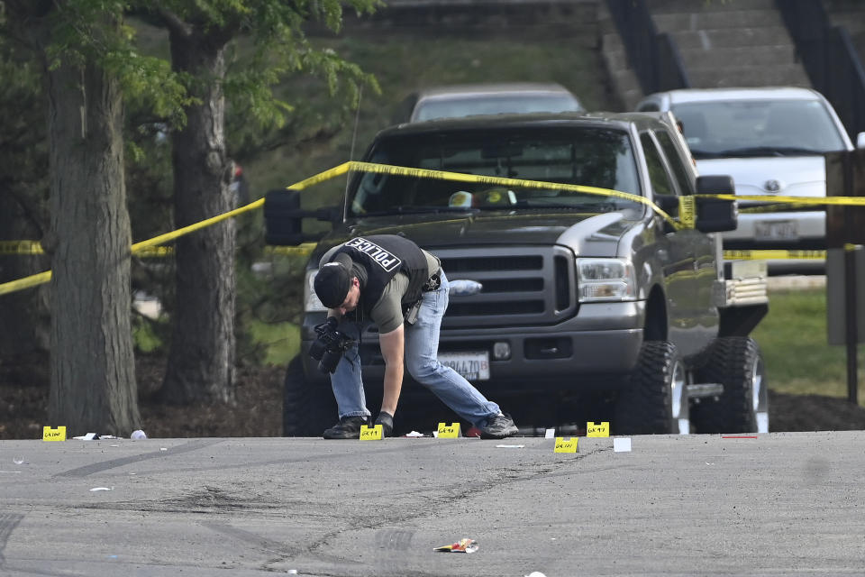 A police officer works the scene of an overnight mass shooting at a strip mall in Willowbrook, Ill., Sunday, June 18, 2023. (AP Photo/Matt Marton)