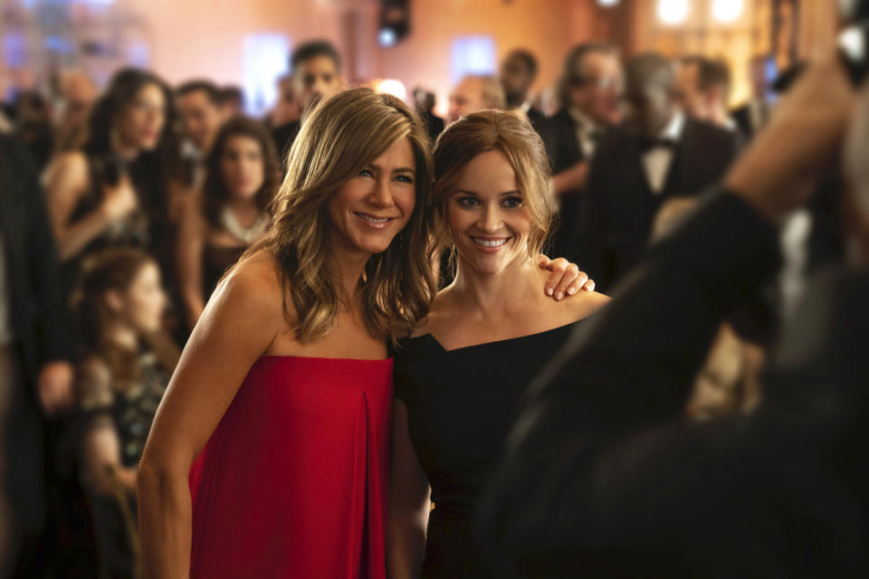 This image released by Apple TV Plus, Jennifer Aniston, left, and Reese Witherspoon appear in a scene from "The Morning Show," behind-the-scenes look at fictional players in the competitive morning broadcast realm. (Apple TV Plus via AP)