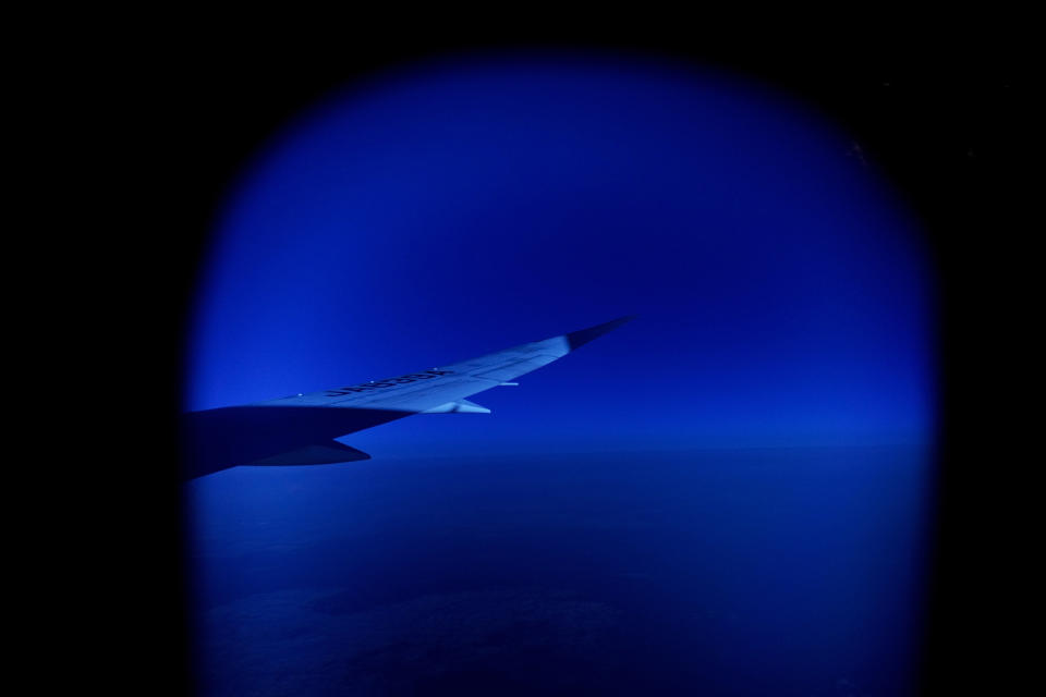 A wing of a plane is seen through a window on a flight Monday, July 19, 2021, from Frankfurt, Germany to Tokyo ahead of the 2020 Summer Olympics. (AP Photo/Natacha Pisarenko)