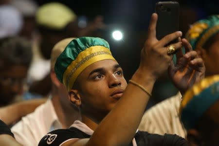 A follower of the Yoruba religion take pictures during the recommendations based on their annual predictions for the New Year during a news conference in Havana, Cuba, January 3, 2017. REUTERS/Alexandre Meneghini