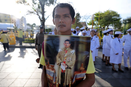 A man holds an image of King Maha Vajiralongkorn during his coronation in Bangkok, Thailand, May 4, 2019. REUTERS/Athit Perawongmetha