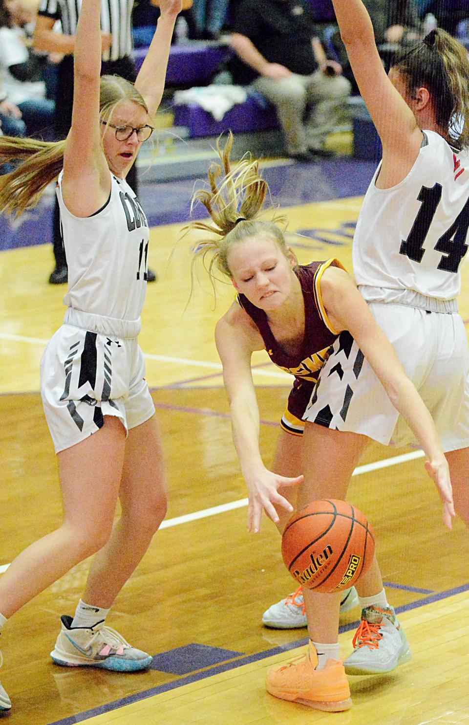 De Smet's Hazel Luethmers splits the defense of Viborg-Hurley's Estelle Lee (left) and Denae Mach during the championship game of the state Class B girls basketball tournament Saturday night in the Watertown Civic Arena. Viborg-Hurley won 58-53.