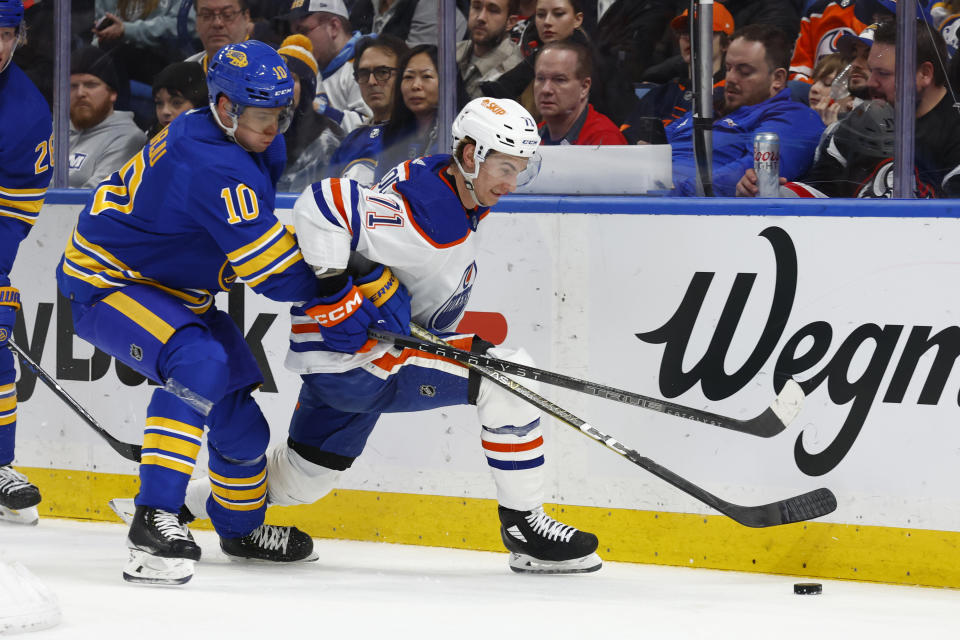 Buffalo Sabres defenseman Henri Jokiharju (10) and Edmonton Oilers center Ryan McLeod (71) battle for the puck behind the net during the second period of an NHL hockey game, Monday, March 6, 2023, in Buffalo, N.Y. (AP Photo/Jeffrey T. Barnes)