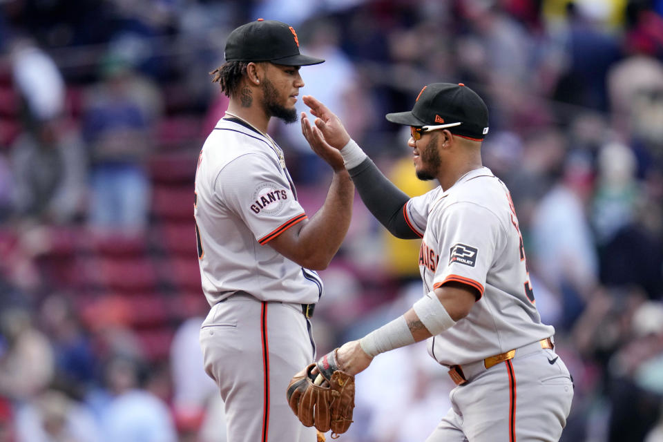 San Francisco Giants pitcher Camilo Doval, left, is congratulated by second baseman Thairo Estrada after defeating the Boston Red Sox 3-1 in a baseball game at Fenway Park, Thursday, May 2, 2024, in Boston. (AP Photo/Charles Krupa)