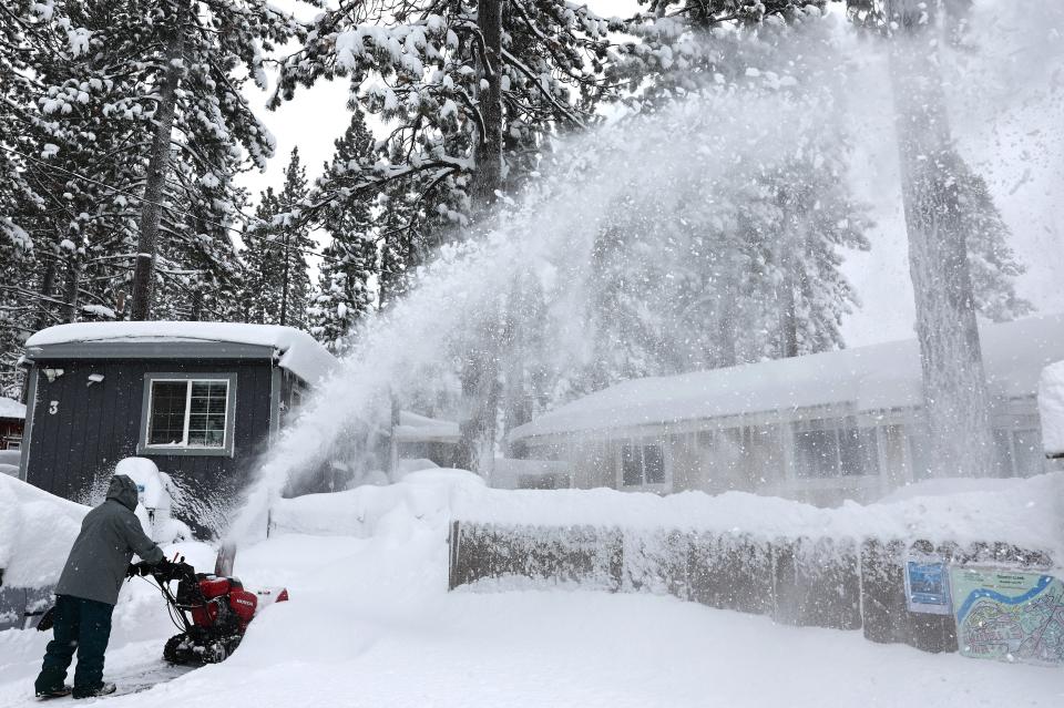A mobile home community resident uses a snowblower during a powerful multiple day winter storm in the Sierra Nevada mountains on Saturday in Truckee, California.