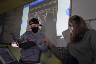 Susannah Remillard, right, works with one of her sixth-grade students at Cape Cod Lighthouse Charter School, Thursday, Nov. 19, 2020, in East Harwich, Mass. In a growing number of U.S. schools, students are now learning a more complex Thanksgiving story that involves conflict, injustice and a new focus on the native people who lived in New England for hundreds of years before European settlers arrived. (AP Photo/Elise Amendola)