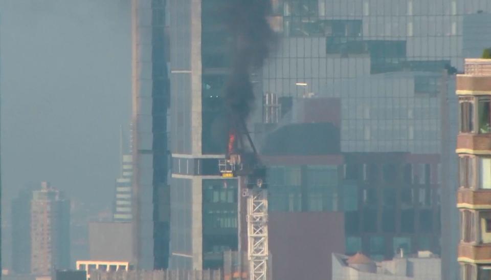 Emergency responders battle flames as a large construction crane caught fire in Manhattan on Wednesday in New York.