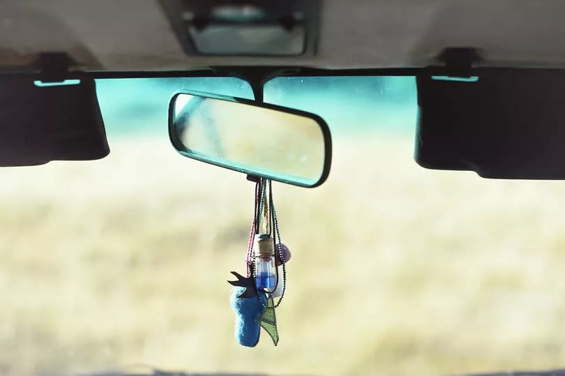 Detail of rear-view mirror in the interior of a rural van.