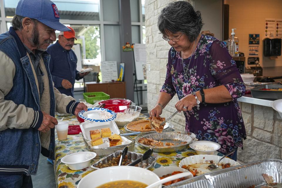 Volunteer Berlinda Chavarria serves food to visitors during a Meals on Wheels event in Del Valle on Nov. 16.