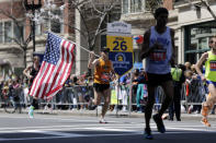 Donny Sazama, of Hermantown, Minn., carries an American flag as he runs past the 26 mile mark of the 118th Boston Marathon Monday, April 21, 2014 in Boston. (AP Photo/Robert F. Bukaty)