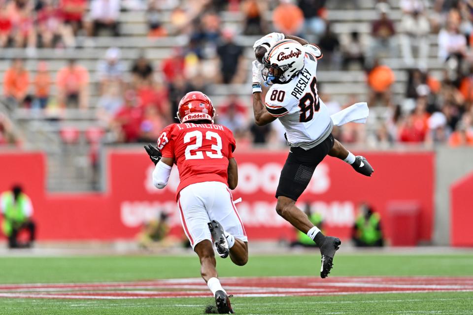 Nov 18, 2023; Houston, Texas, USA; Oklahoma State Cowboys wide receiver Brennan Presley (80) catches a pass as Houston Cougars defensive back Isaiah Hamilton (23) defends during the first quarter at TDECU Stadium. Mandatory Credit: Maria Lysaker-USA TODAY Sports