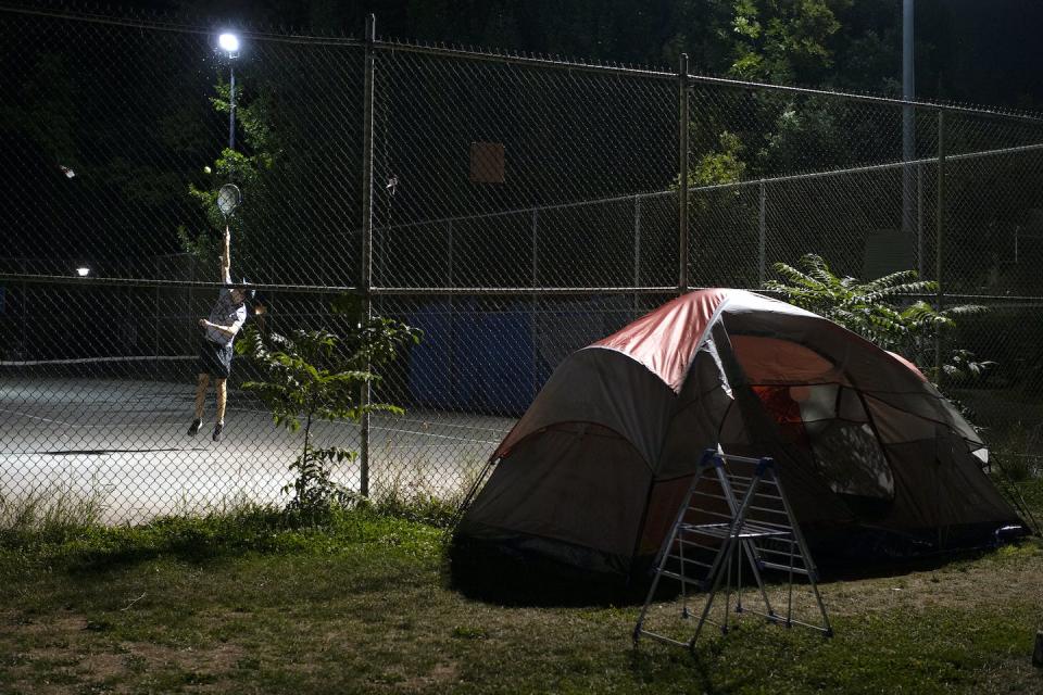 A man plays tennis next to a homeless encampment in Toronto in September 2020. THE CANADIAN PRESS/Chris Young