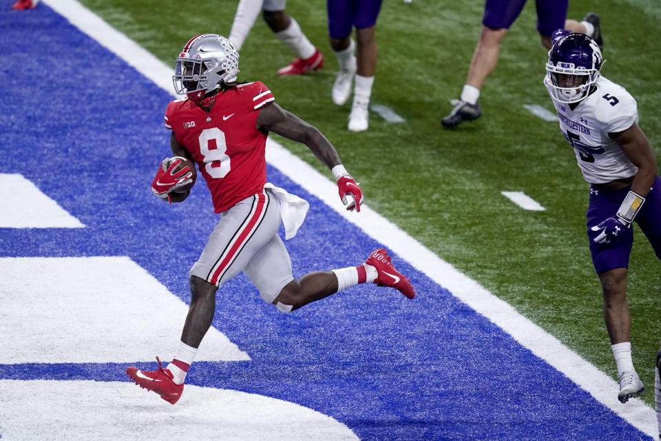 Ohio State running back Trey Sermon (8) scores past Northwestern defensive back JR Pace (5) during the second half of the Big Ten championship NCAA college football game, Saturday, Dec. 19, 2020, in Indianapolis. (AP Photo/Darron Cummings)