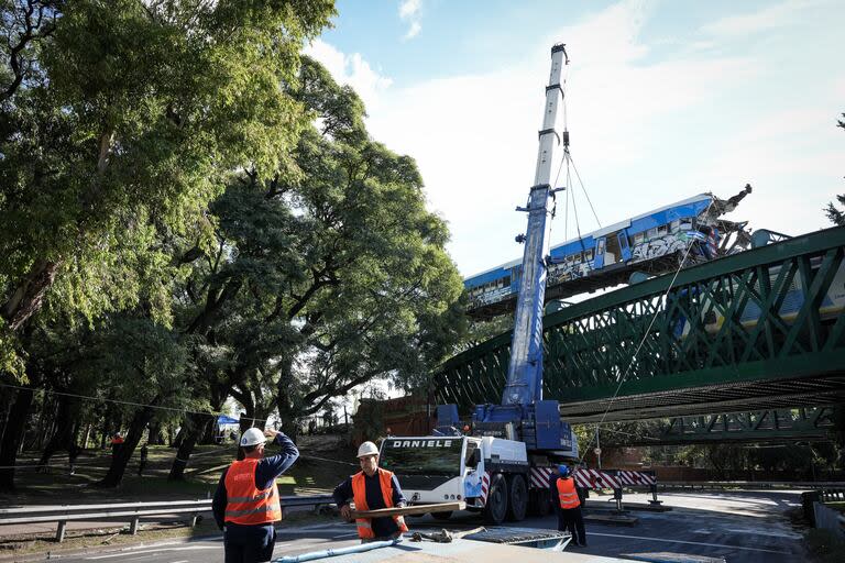 Una grúa de gran porte retira el vagón chocado, en las vías del tren San Martín