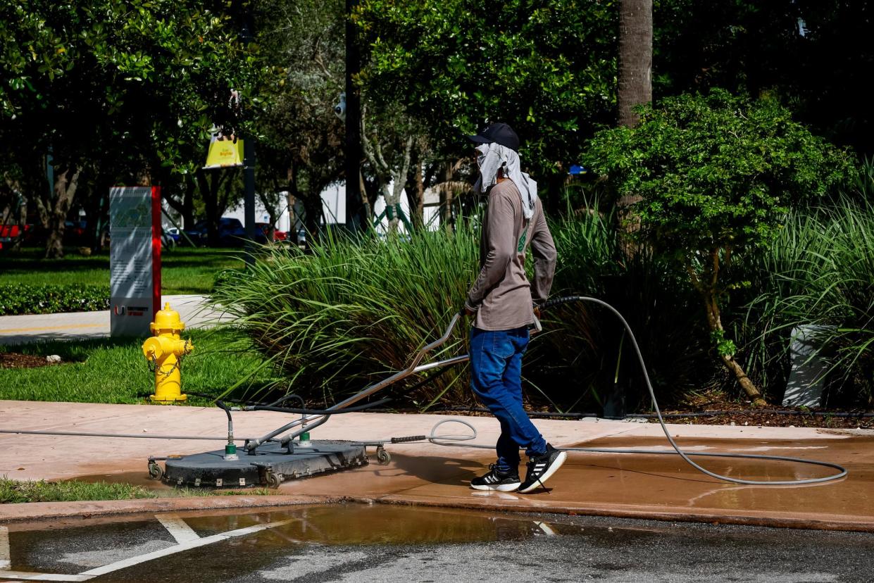 <span>A worker cleans a sidewalk during a heatwave in Miami, Florida, on 25 July 2023.</span><span>Photograph: Eva Marie Uzcategui/Bloomberg via Getty Images</span>