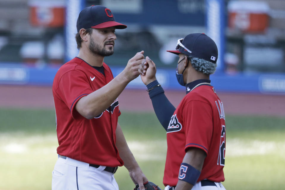 Cleveland Indians relief pitcher Brad Hand, left, is congratulated by Francisco Lindor after the Indians defeated the Chicago White Sox 4-3 in the first baseball game of a doubleheader, Tuesday, July 28, 2020, in Cleveland. (AP Photo/Tony Dejak)