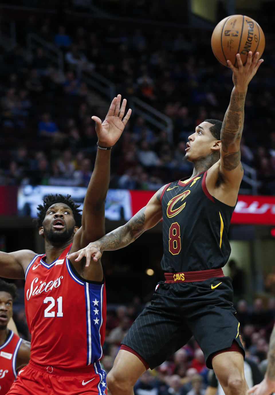 Cleveland Cavaliers' Jordan Clarkson (8) shoots over Philadelphia 76ers' Joel Embiid (21), from Cameroon, during the first half of an NBA basketball game Sunday, Dec. 16, 2018, in Cleveland. (AP Photo/Ron Schwane)