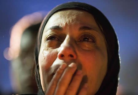 A woman cries as a video is played during a vigil on the campus of the University of North Carolina, for Deah Shaddy Barakat, his wife Yusor Mohammad and Yusor's sister Razan Mohammad Abu-Salha who were killed in Chapel Hill, North Carolina February 11, 2015. REUTERS/Chris Keane