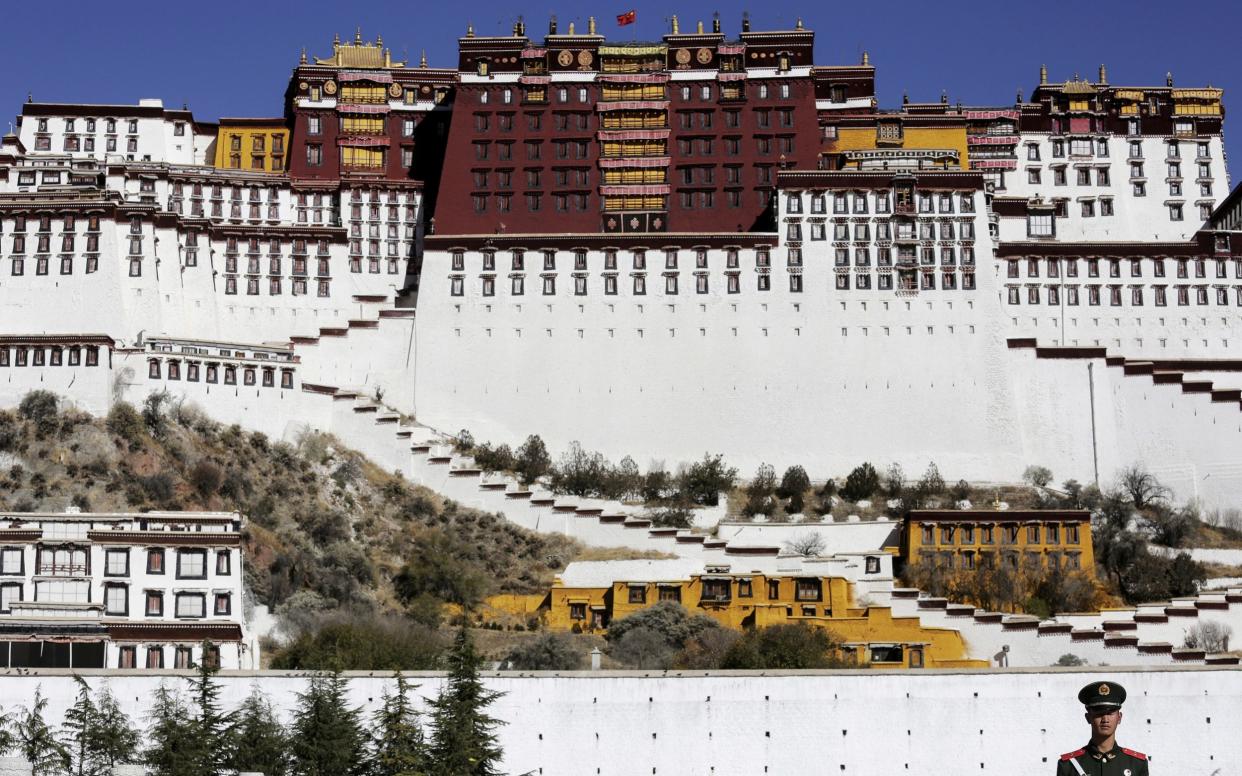 A paramilitary policeman stands guard in front of the Potala Palace in Lhasa, Tibet - REUTERS/Damir Sagolj/File Photo