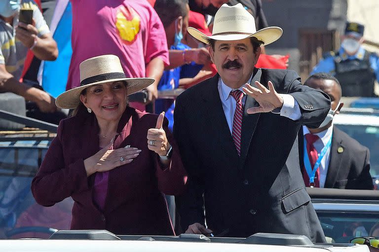 La presidenta electa de Honduras, Xiomara Castro, levanta el pulgar mientras su esposo, el expresidente hondureño (2006-2009), Manuel Zelaya, saluda mientras son conducidos por el bulevar Suyapa hacia el Estadio Nacional, donde se llevará a cabo la ceremonia de toma de posesión