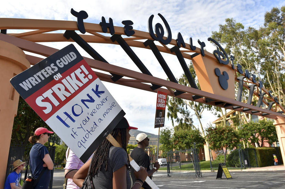 Manifestantes con carteles fuera de los estudios de Disney el lunes 17 de julio de 2023 en Burbank, California. La huelga de actores se produce más de dos meses después de que los guionistas comenzaran a hacer huelga en su intento por obtener mejores salarios y condiciones laborales y tener pautas claras sobre el uso de inteligencia artificial en producciones de cine y televisión.(Jordan Strauss/Invision/AP)