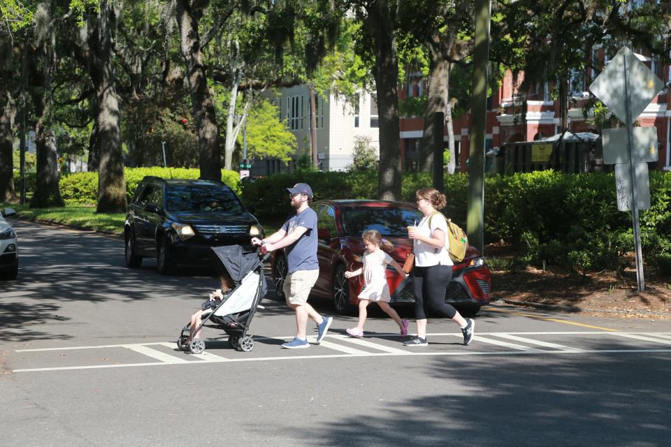 A family uses a crosswalk to cross Oglethorpe Avenue on Bull Street.