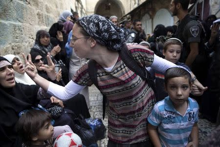 An Israeli woman (C) and a Palestinian woman gesture at one another during a protest by Palestinian women against Jewish visitors to the compound known to Muslims as Noble Sanctuary and to Jews as Temple Mount in Jerusalem's Old City October 14, 2014. REUTERS/Finbarr O'Reilly