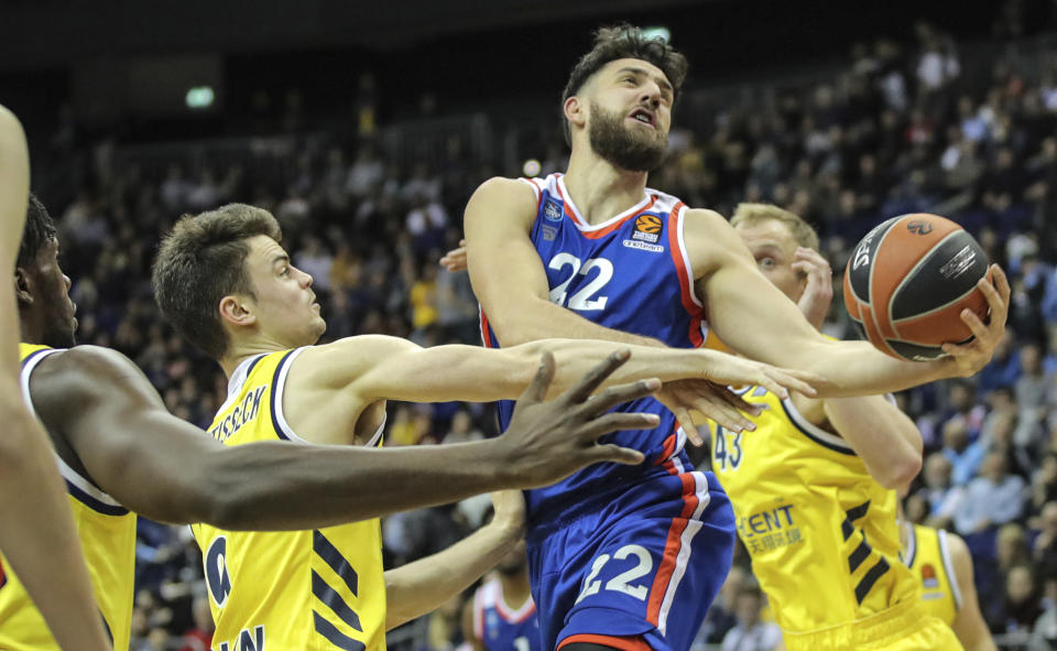 Vasilije Micic from Efes Istanbul, centre, jumps to the basket through the defense of Albas' Jonas Mattisseck, left, and Luke Sikma, right, during their Euroleague main round basketball match at the Mercedes-Benz Arena in Berlin, Germany, Thursday Feb. 27, 2020. (Andreas Gora/dpa via AP)