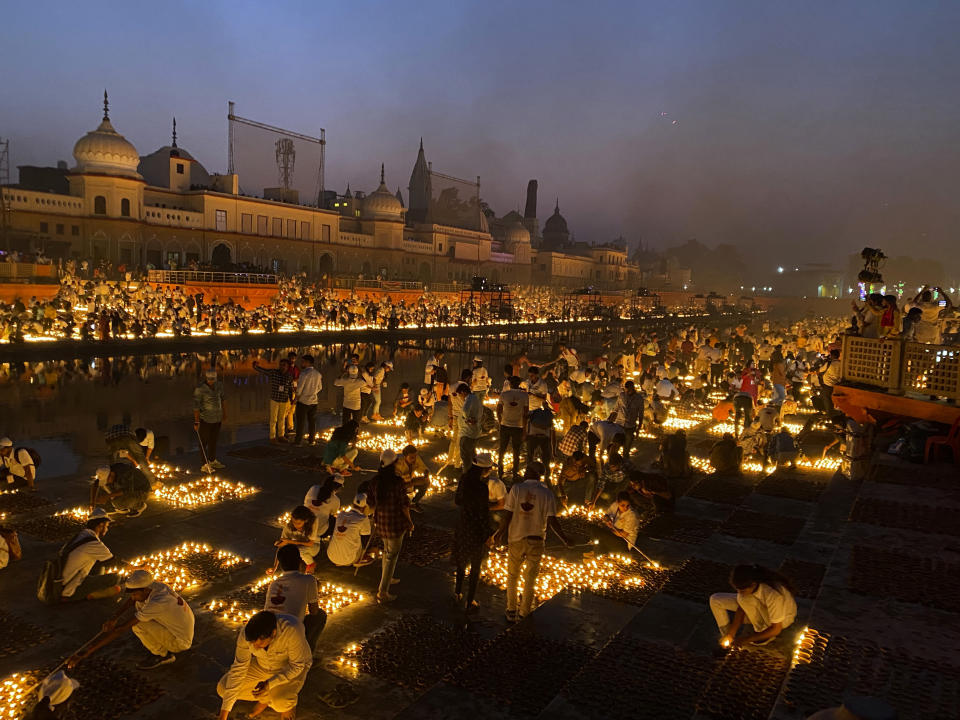 People light lamps on the banks of the river Saryu in Ayodhya, India, Wednesday, Nov. 3, 2021. Over 900,000 earthen lamps were lit and were kept burning for 45 minutes as the north Indian city of Ayodhya retained its Guinness World Record for lighting oil lamps as part of the Diwali celebration – the Hindu festival of lights. (AP Photo/Rajesh Kumar Singh)