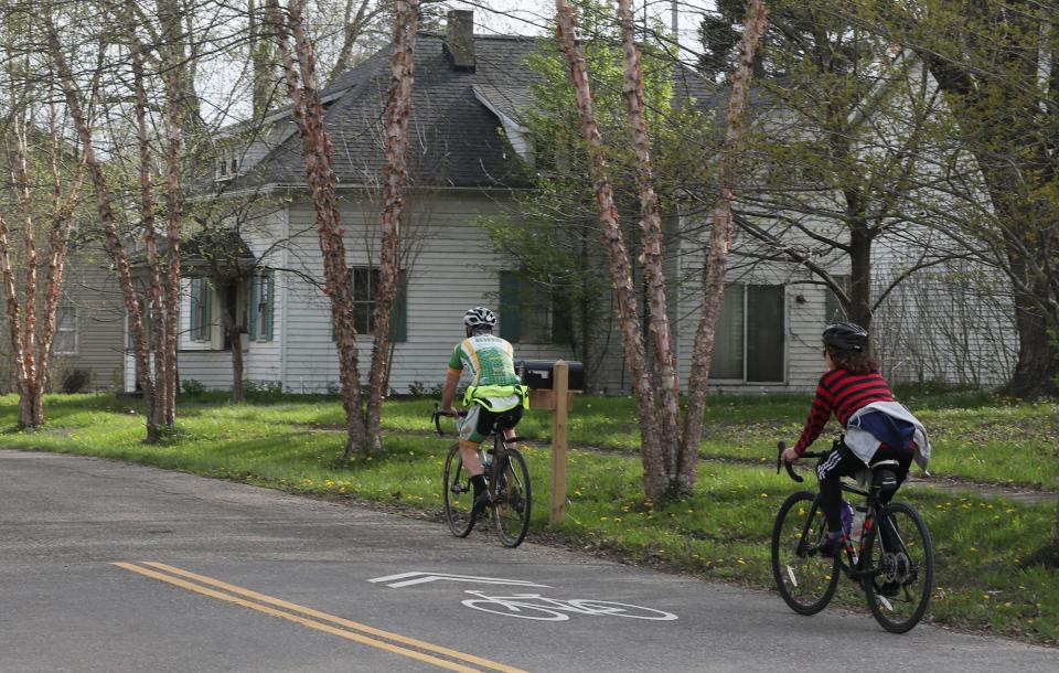 Bicyclists ride on Canal Street along the Ohio & Erie Canal Towpath Trail through downtown Bolivar on Saturday.