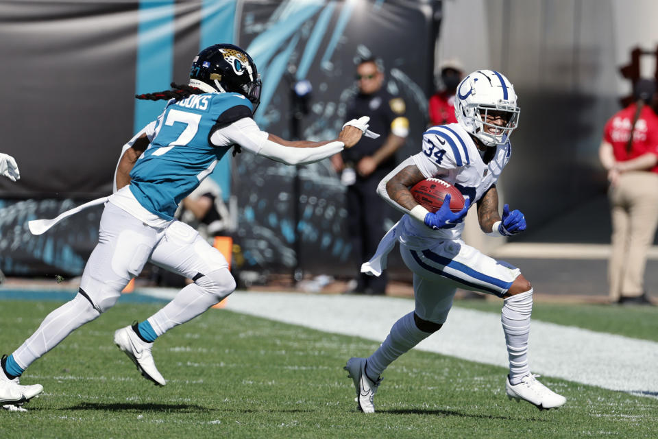 Indianapolis Colts cornerback Isaiah Rodgers (34) runs past Jacksonville Jaguars cornerback Chris Claybrooks, left, during the first half of an NFL football game, Sunday, Jan. 9, 2022, in Jacksonville, Fla. (AP Photo/Stephen B. Morton)