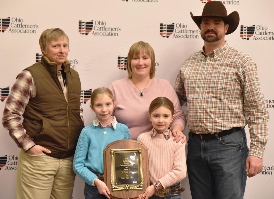 Amy Porteus and her sister Beth Mullen with her husband, Cole, and their two daughters, Rylee and Harper, recently accepted the Environmental Stewardship Award from the Ohio Cattlemen's Association. They work the farm with Amy and Beth's father, Brent Porteus, and his brother, Knox Porteus.