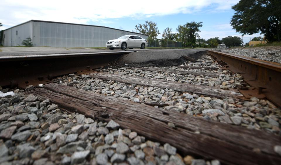 A car passes by the railroad tracks along Martin St. in Wilmington, N.C., Monday, September 28, 2020. The city of Wilmington is undertaking a study that will identify feasible alternatives that could be considered for the rail realignment project. The project aims to replace and improve the existing freight rail route between Navassa Yard and the Port of Wilmington.