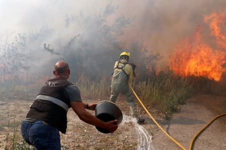Firefighters help to put out a forest fire near the village of Vila de Rei,