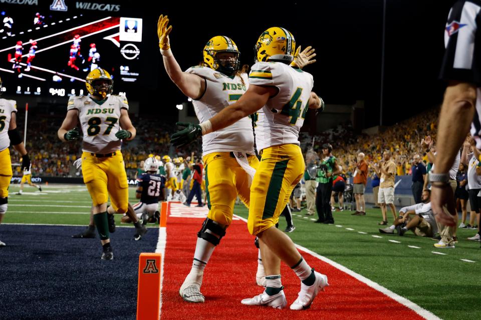 FILE - North Dakota State fullback Hunter Luepke (44) hugs offensive tackle Cody Mauch after scoring a touchdown against Arizona during the second half of an NCAA college football game Saturday, Sept. 17, 2022, in Tucson, Ariz. Not all players worthy of NFL talent scout consideration play in the Power Five conferences. (AP Photo/Chris Coduto, File)
