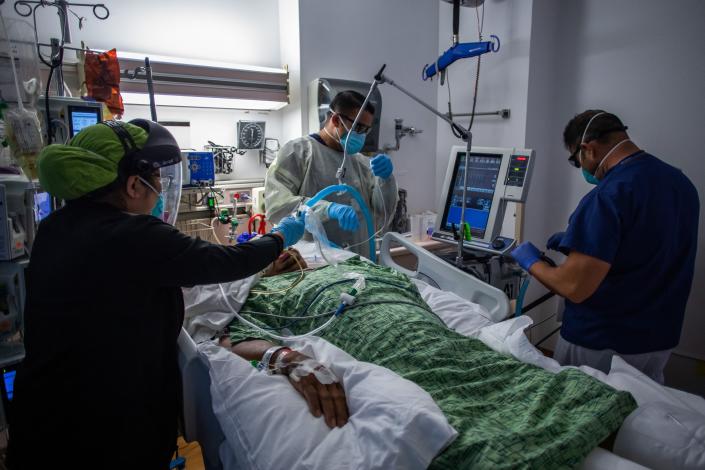 Health care workers treat a COVID patient