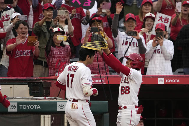 Shohei Ohtani, left, is given a Kabuto by a bat boy after hitting a two-run home run against the Seattle Mariners on Friday night in Anaheim, Calif. (AP Photo/Mark J. Terrill)